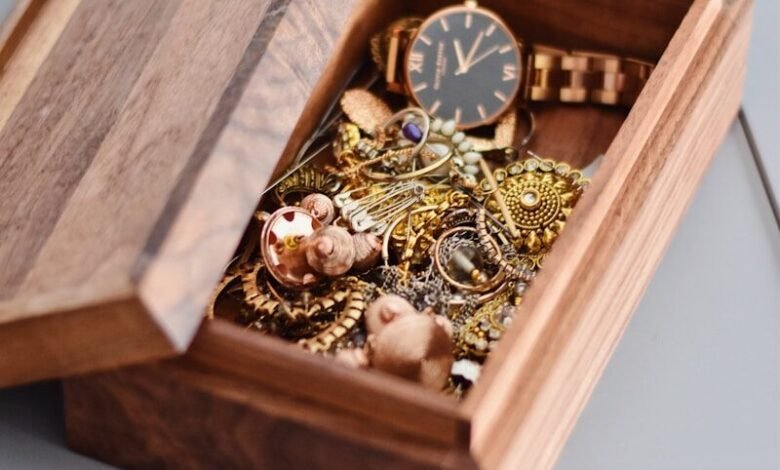 gold watch and pendant on brown wooden box