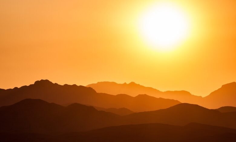 silhouette of mountains under orange sky
