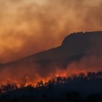 wildfire burning across hillside at dusk