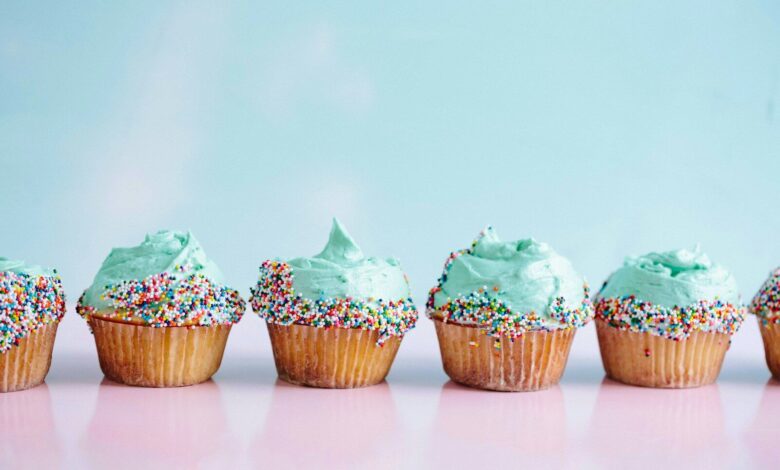 six teal icing cupcakes with sprinkles