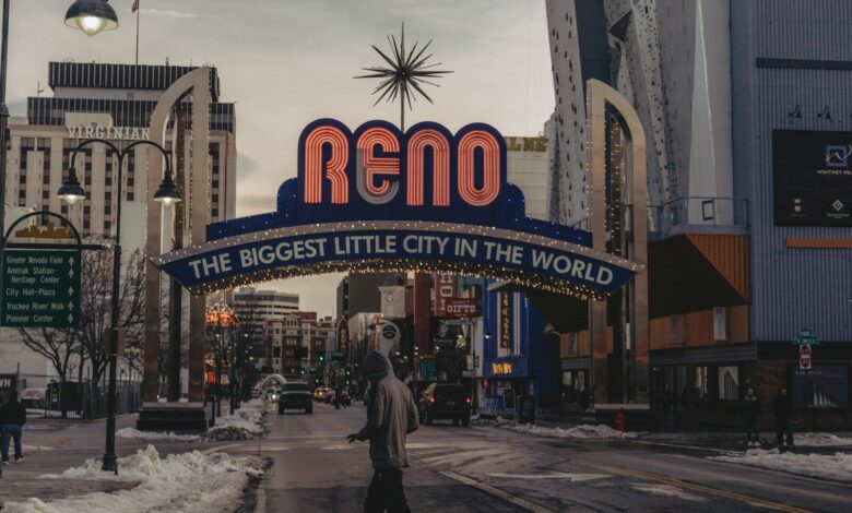 a man walking down a street under a neon sign