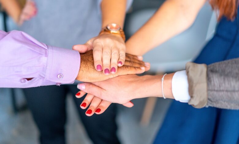 Close-up of diverse hands joined in a symbol of unity and teamwork.