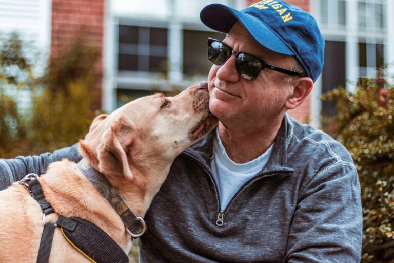 dog licking man's neck